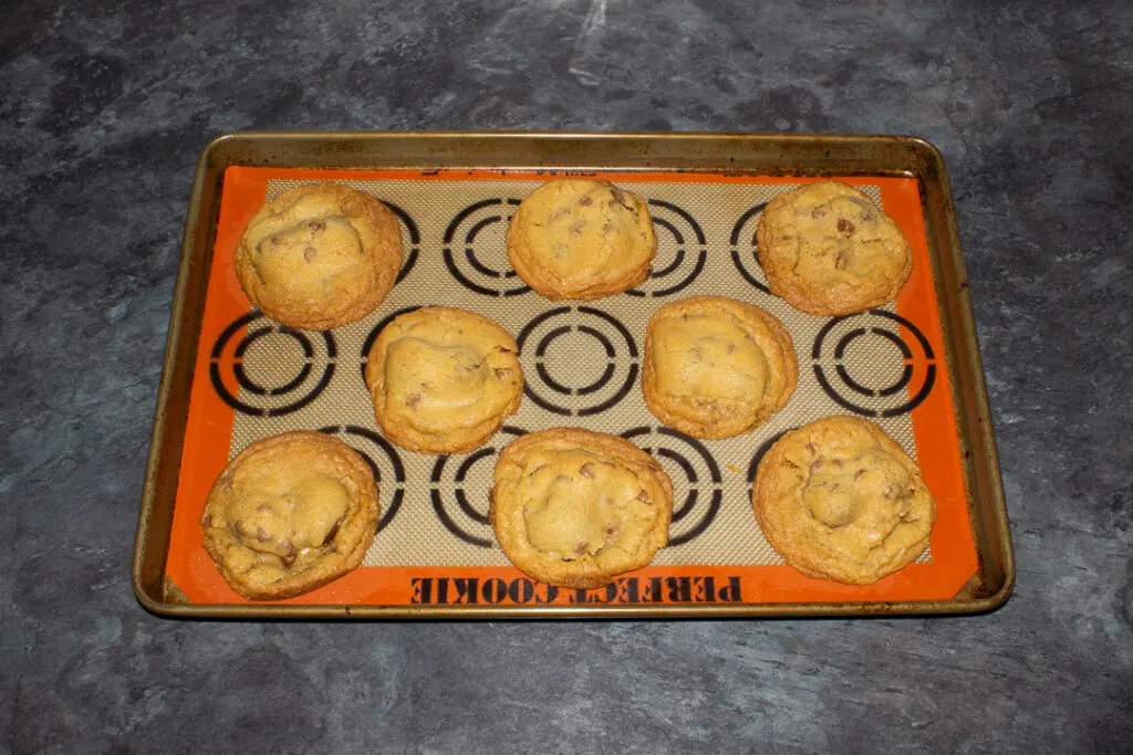 Baked Creme Egg cookies on a lined baking tray