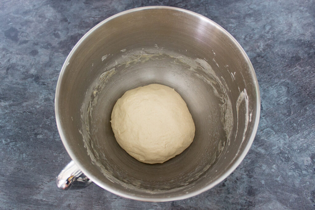 Pizza dough in the bowl of an electric stand mixer
