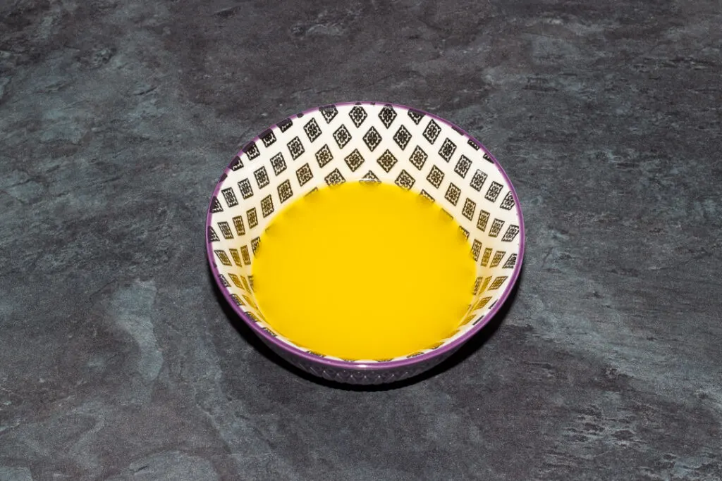 Melted butter in a small bowl on a kitchen worktop