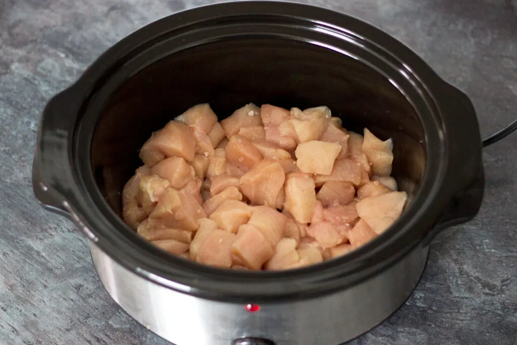 Diced chicken in a slow cooker.