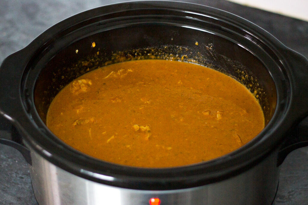 Chicken curry nearly cooked in a slow cooker with the lid off.