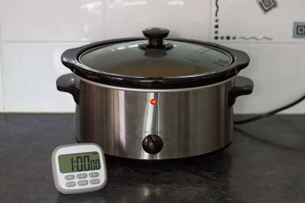 Slow cooker chicken curry in a slow cooker with a timer on display in front.