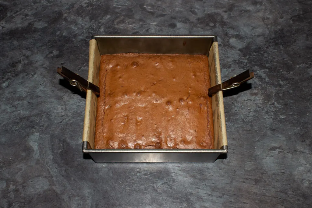 Baked Twix brownie in a lined square baking tin.