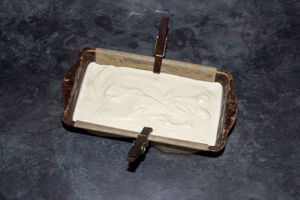 Vanilla ice cream in a lined baking tin.