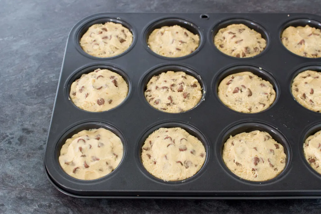 Unbaked Nutella Lava Cookies in a cupcake/muffin tin ready to be baked in the oven.