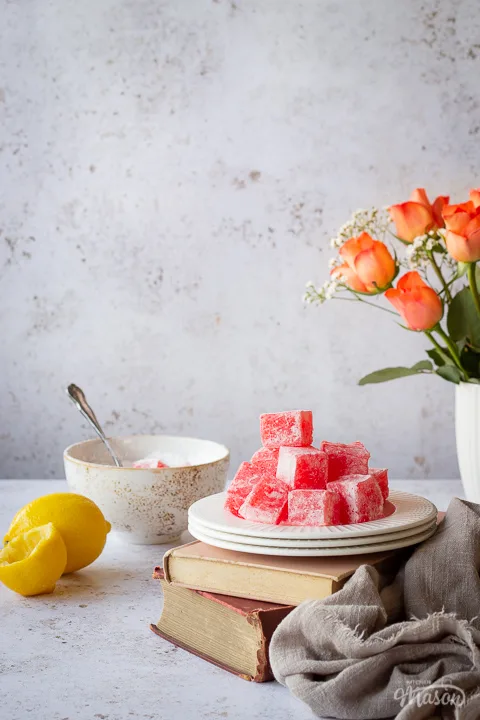 Turkish delight on a plate over books, with squeezed lemon at the side