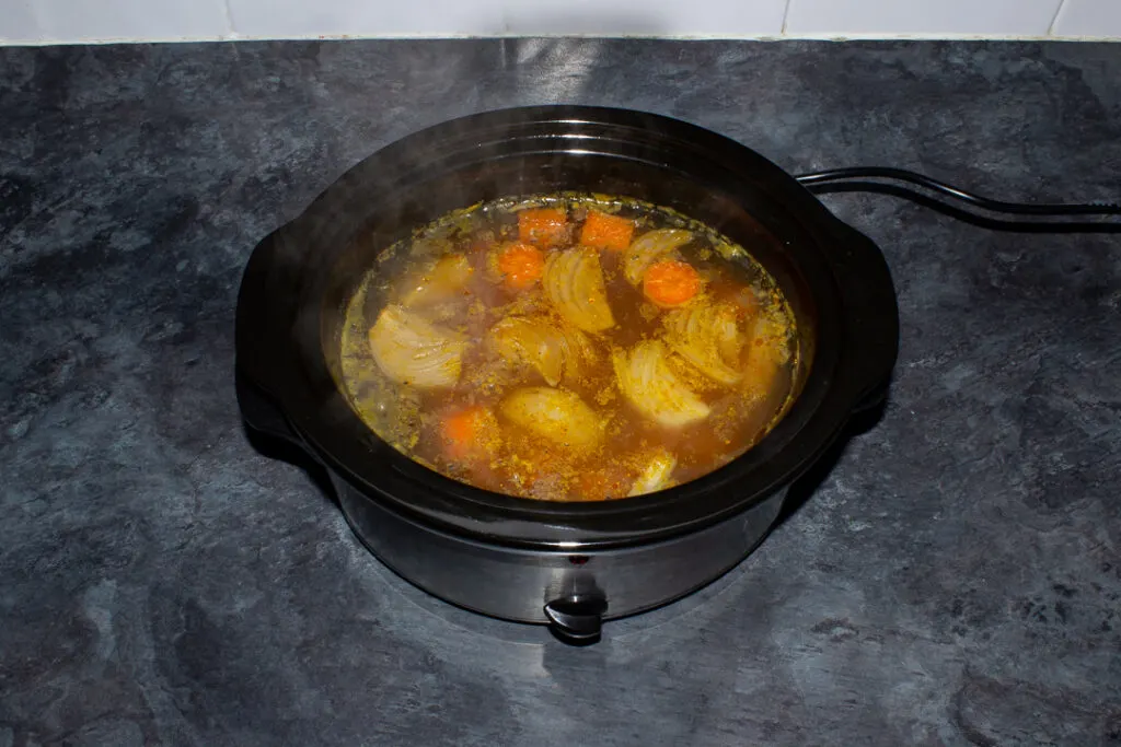 Cooked slow cooker carrot soup in a slow cooker on a kitchen worktop.