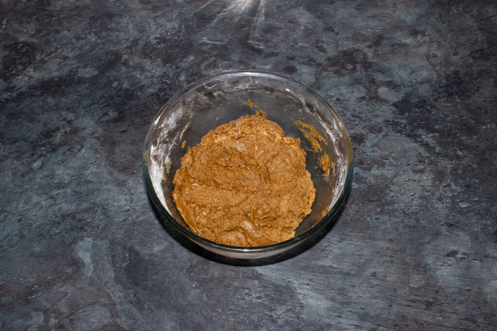 Gingerbread biscuit dough in a large bowl on a kitchen worktop.