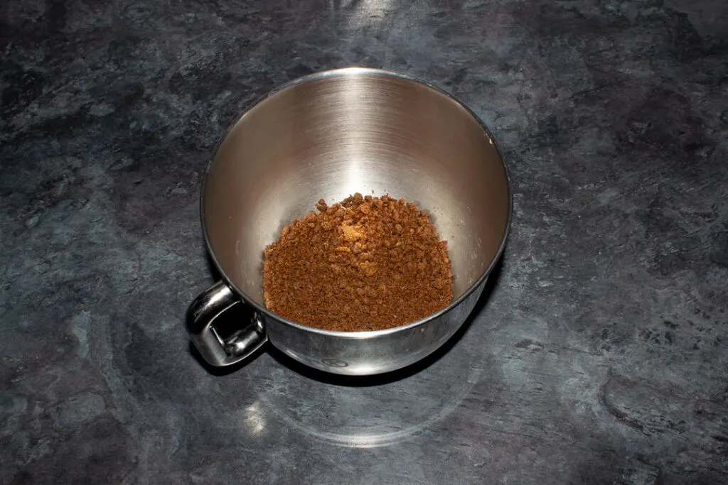 Dark muscovado sugar in a large silver bowl on a kitchen worktop.