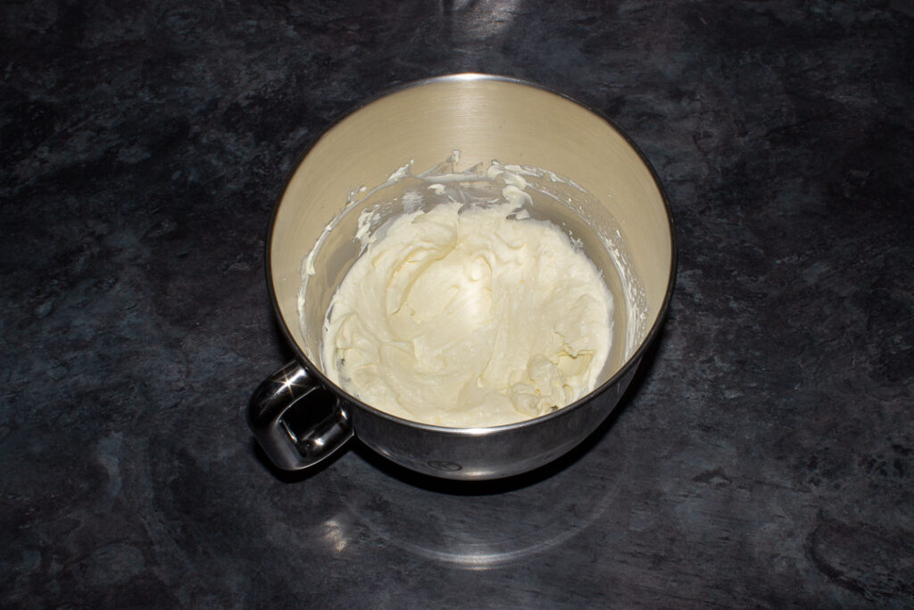 Butter and cream cheese creamed together in a large silver bowl. Set on a kitchen worktop.