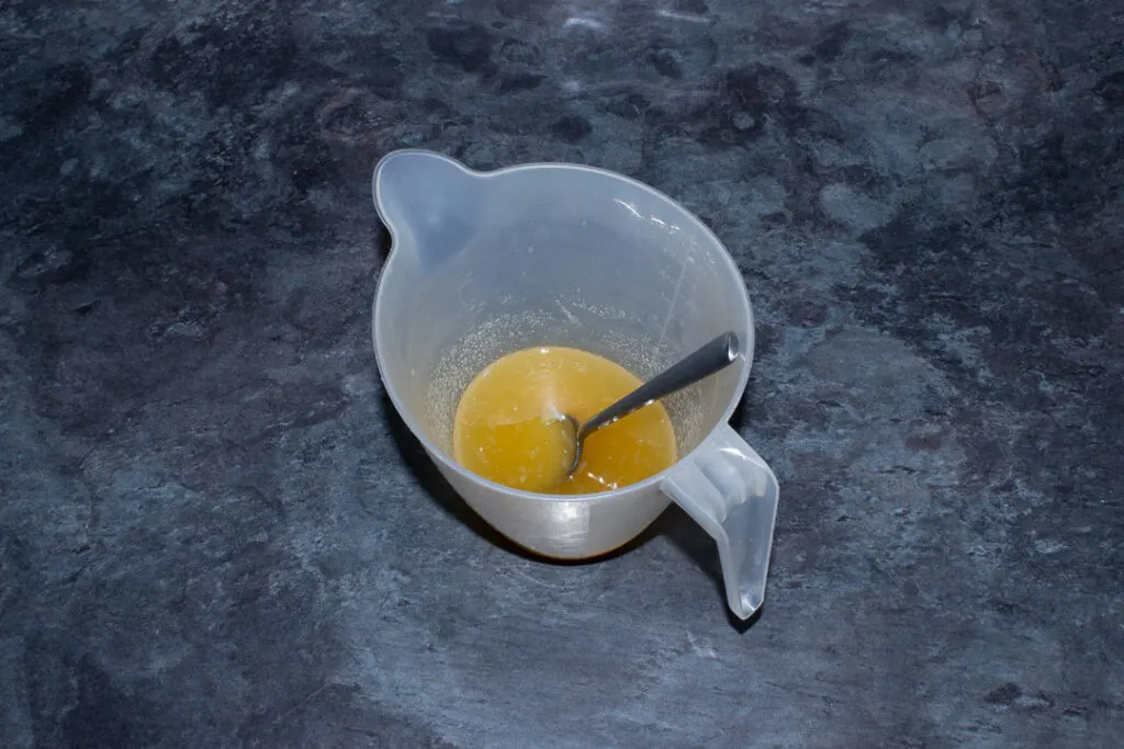 Lemon juice and caster sugar mixed together in a jug on a kitchen worktop.