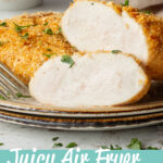 A real close up shot of a sliced juicy air fryer chicken breast on a plate with a fork. Set against a mottled white backdrop. A text overlay says "Juicy Air Fryer Chicken Breast"