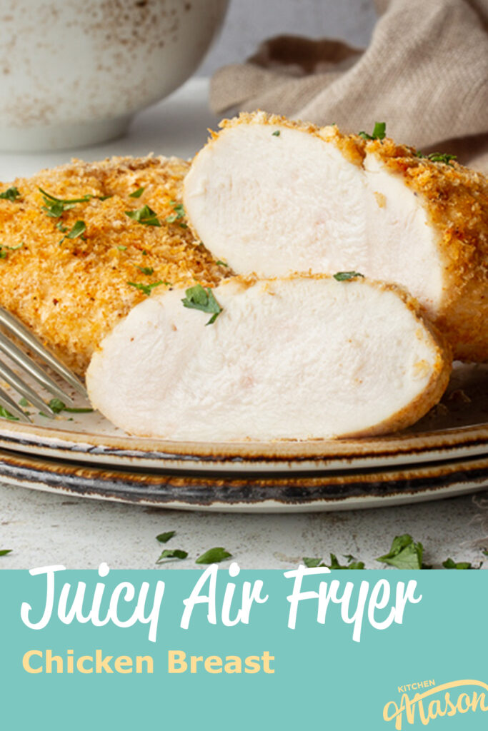A real close up shot of a sliced juicy air fryer chicken breast on a plate with a fork. Set against a mottled white backdrop. A text overlay says "Juicy Air Fryer Chicken Breast"