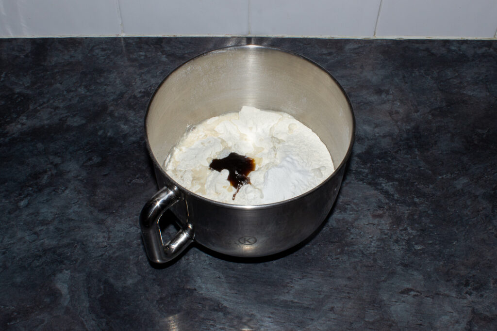 Biscoff cake batter ingredients in the bowl of an electric stand mixer on a kitchen worktop.