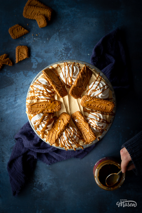 A flat lay view of a freshly decorated Lotus Biscoff cake on a cake stand.