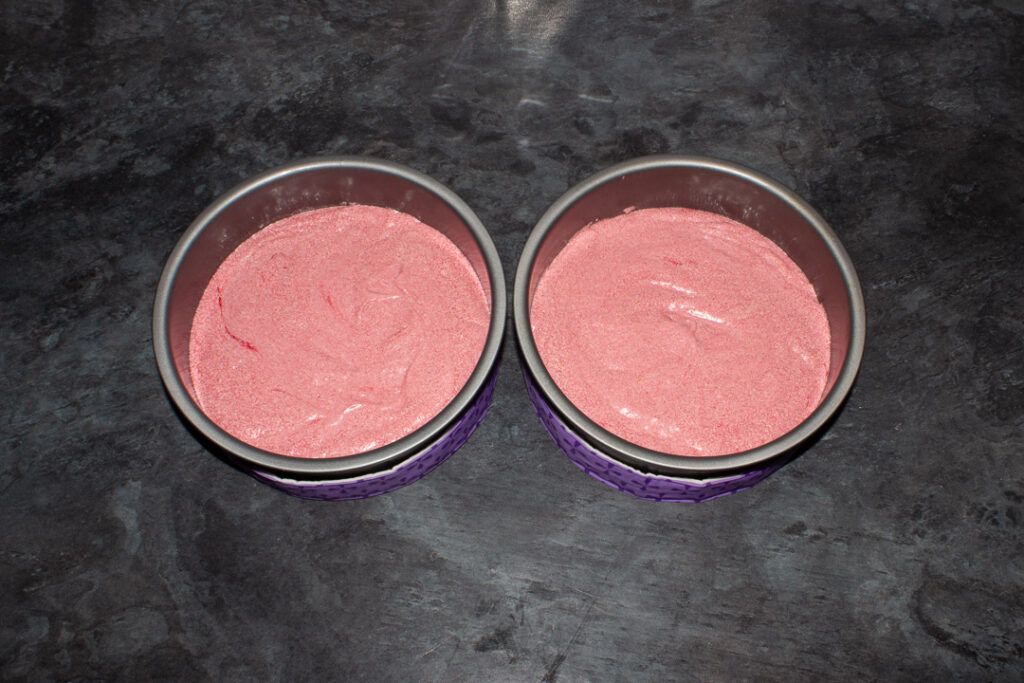 Strawberry cake batter in two round cake tins.