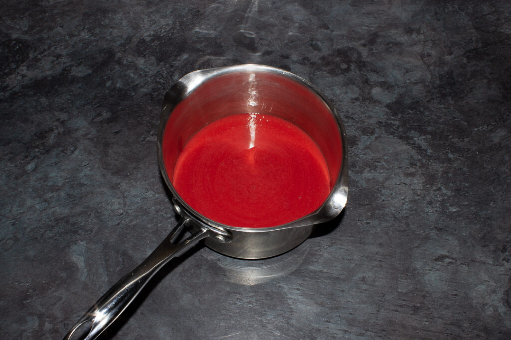 Sieved blended strawberries in a saucepan