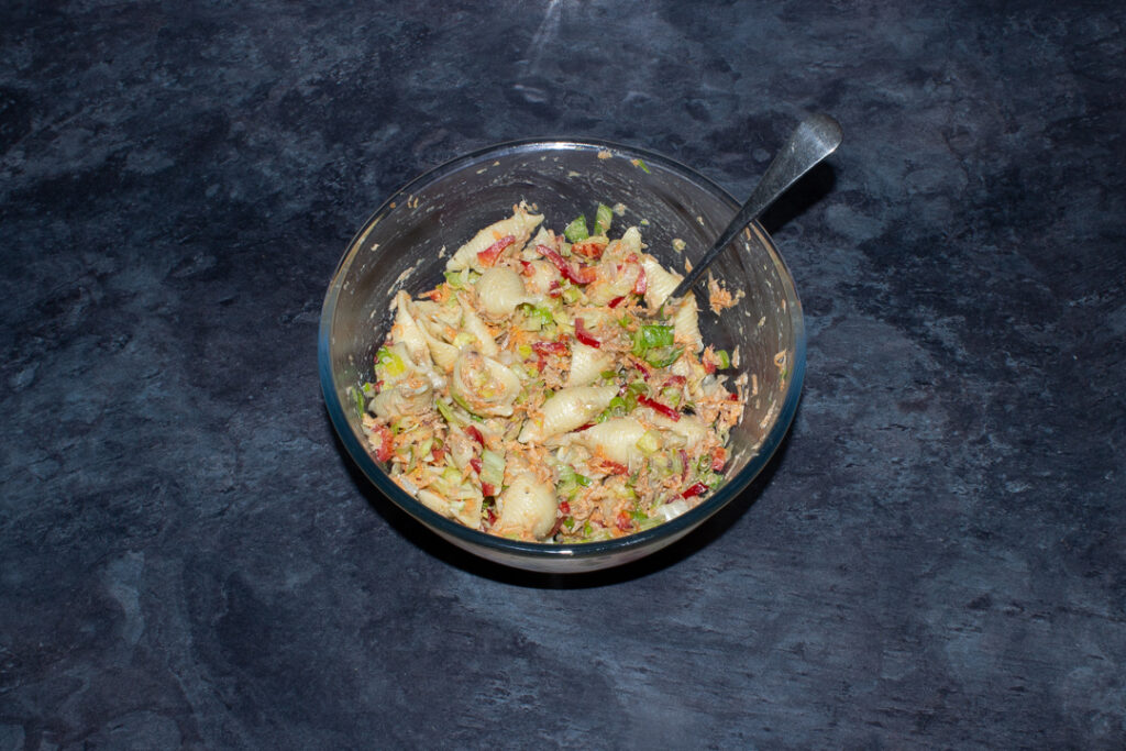 Tuna salad pasta in a glass bowl with a spoon
