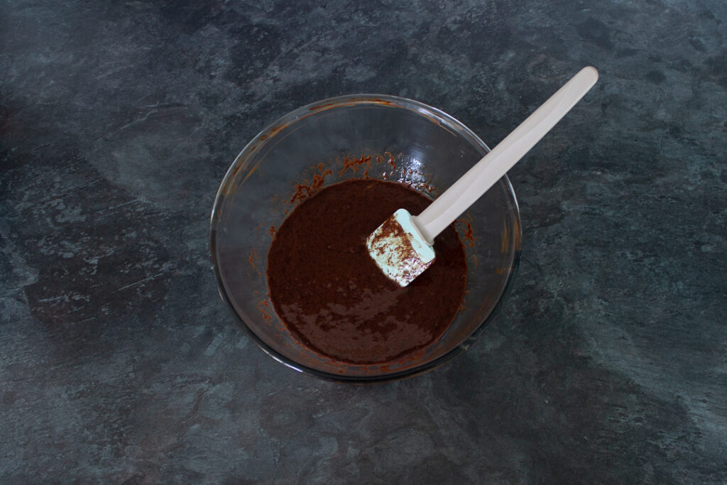 Melted butter, chocolate and eggs mixed in a bowl.