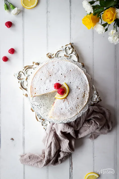 Top down view of a lemon raspberry cake on a stand.
