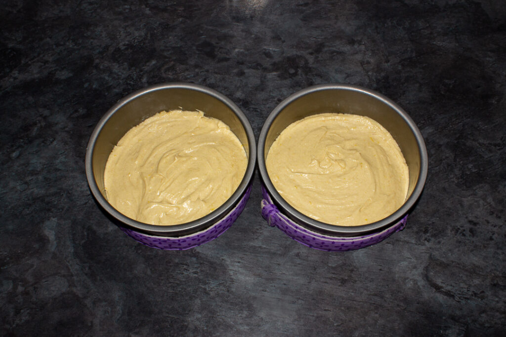 Cake batter in two lined baking tins.