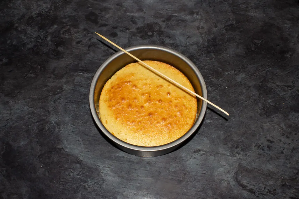 Lemon cake being poked with a skewer.