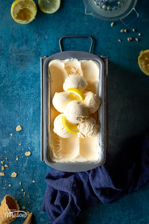 Lemon ice cream in a loaf tin with scoops in the middle