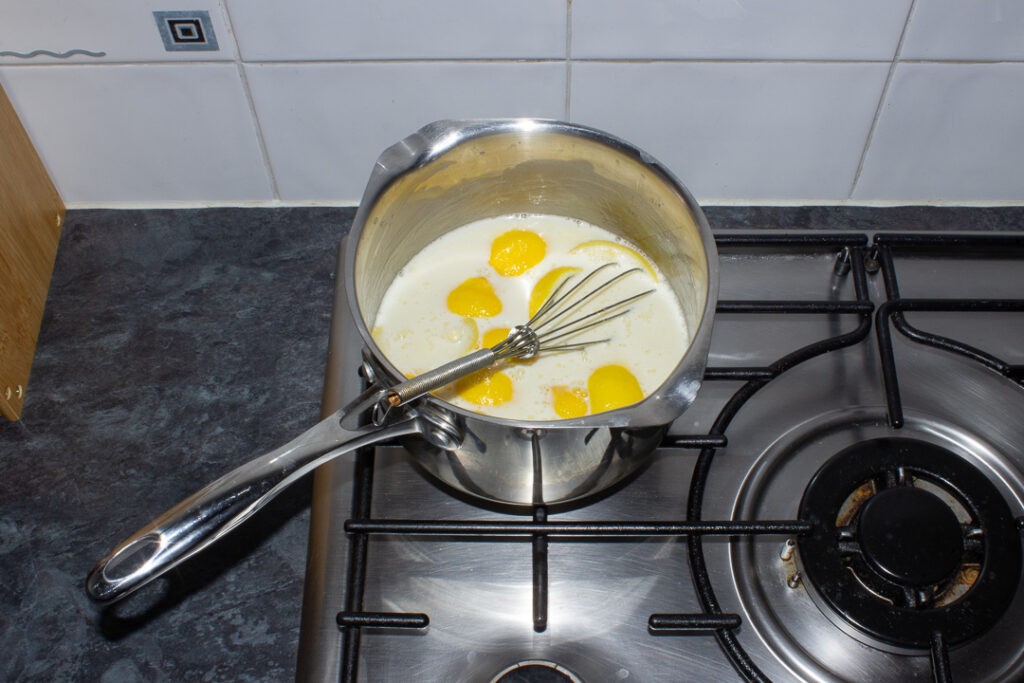 Lemon custard ingredients in a saucepan on the hob