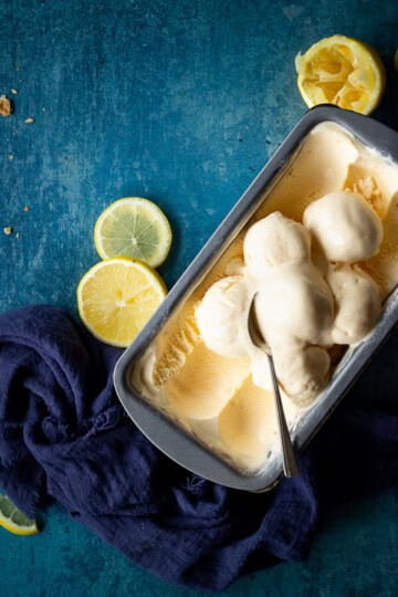 Homemade lemon ice cream and a spoon in a loaf tin