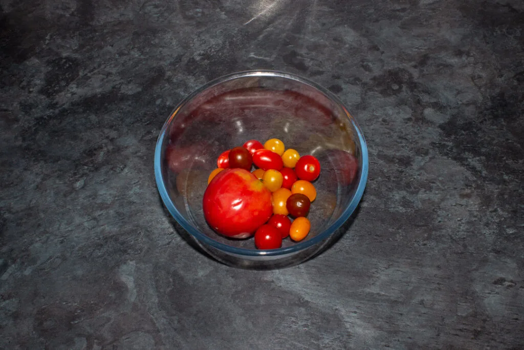Various varieties of tomatoes in a glass mixing bowl