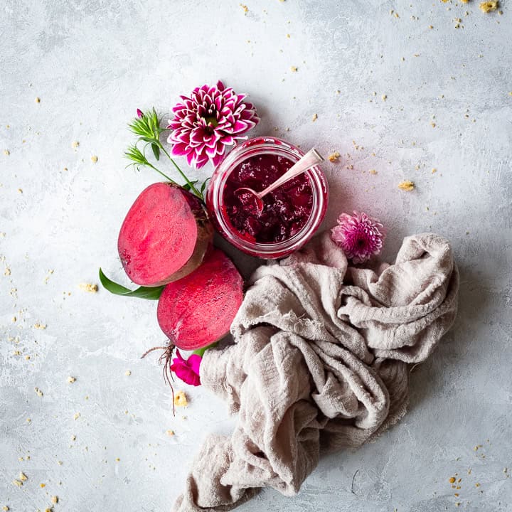 Halved beetroot with a jar of chutney and flowers