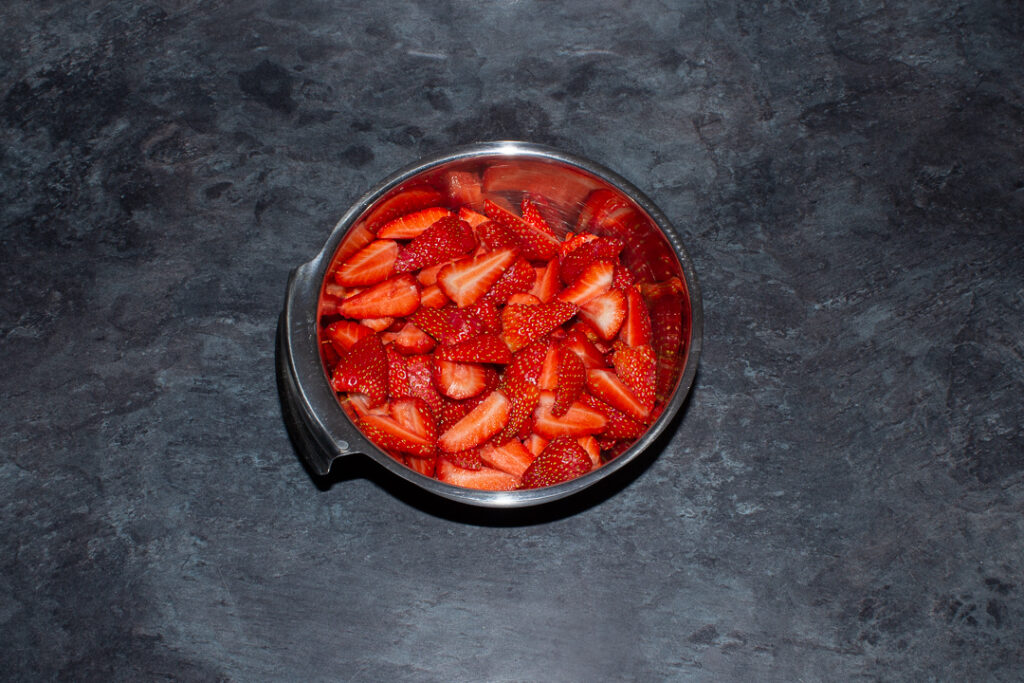 Chopped strawberries in a metal bowl