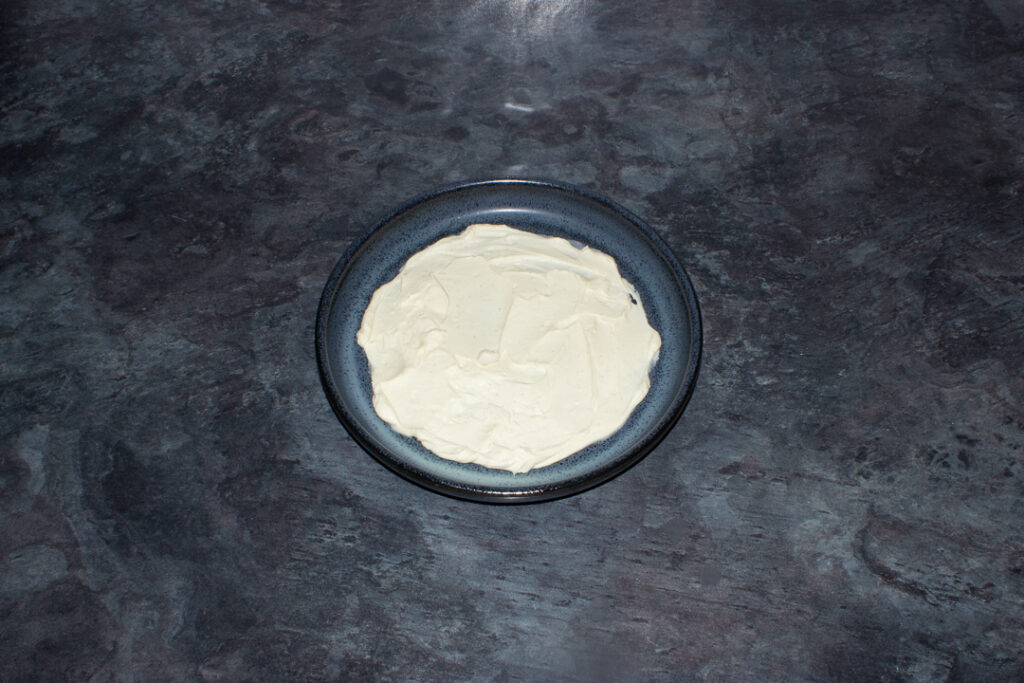 Sweetened whipped vanilla cream spread on a blue plate