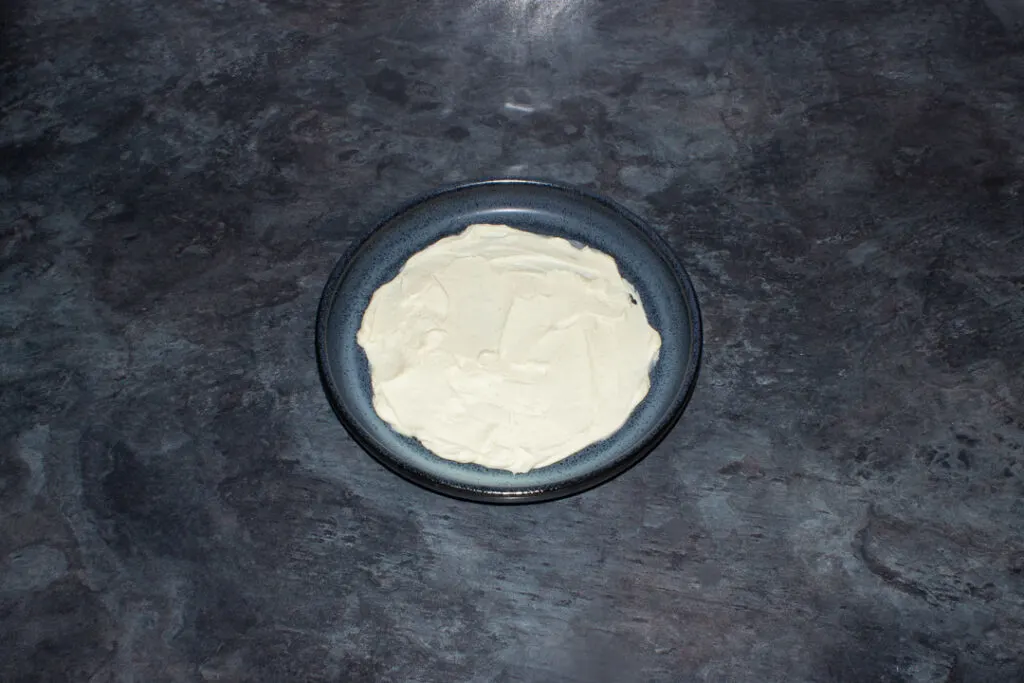 Sweetened whipped vanilla cream spread on a blue plate
