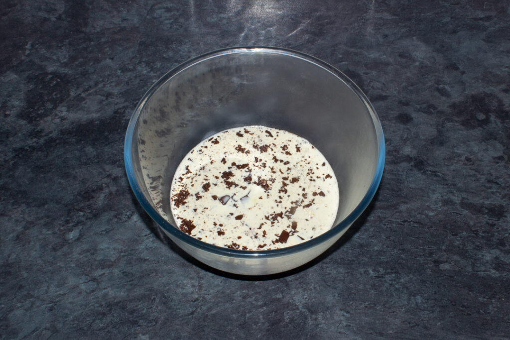 Hot cream and chopped chocolate in a bowl