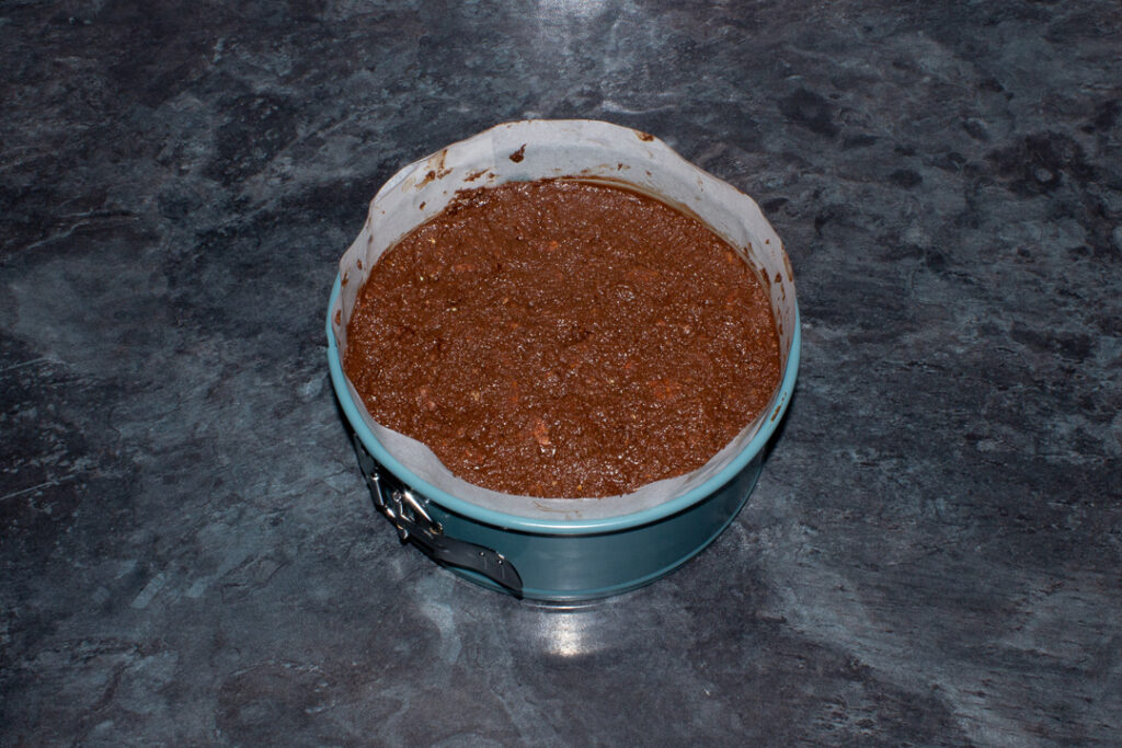 Biscuit cake mixture pressed into a lined springform pan
