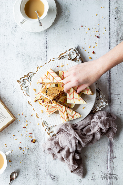 Someone reaching for a slice of no bake white chocolate tiffin