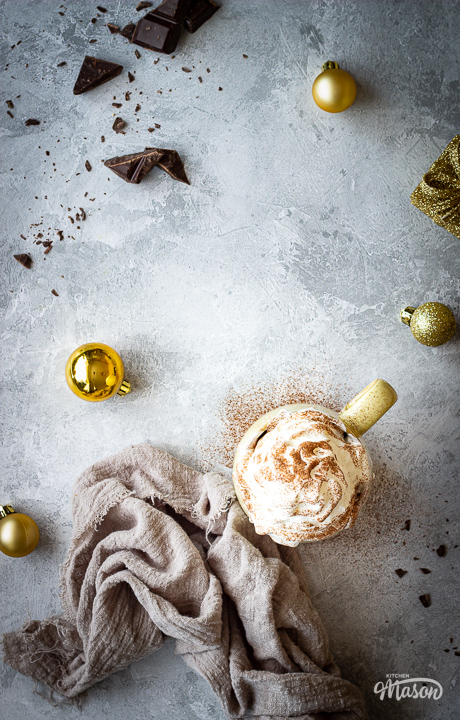 A mug of Christmas spiced hot chocolate with gold baubles
