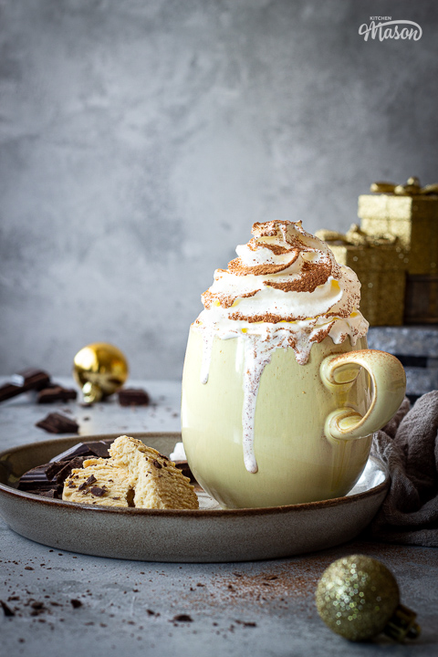 Christmas spiced hot chocolate with cream dripping down the side of the mug