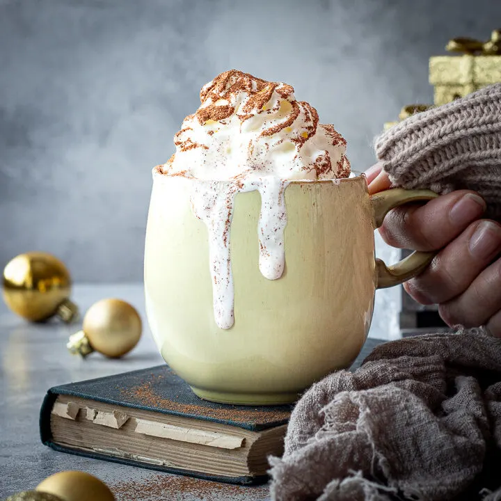 Someone holding a mug of Christmas hot chocolate