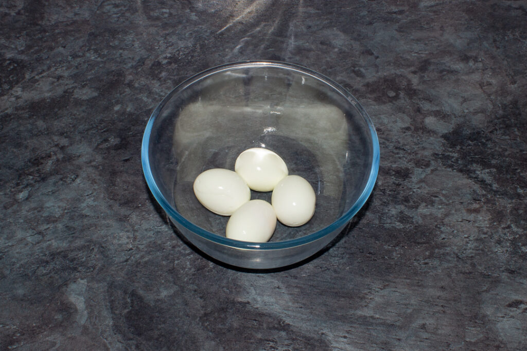 4 peeled hard boiled eggs in a bowl