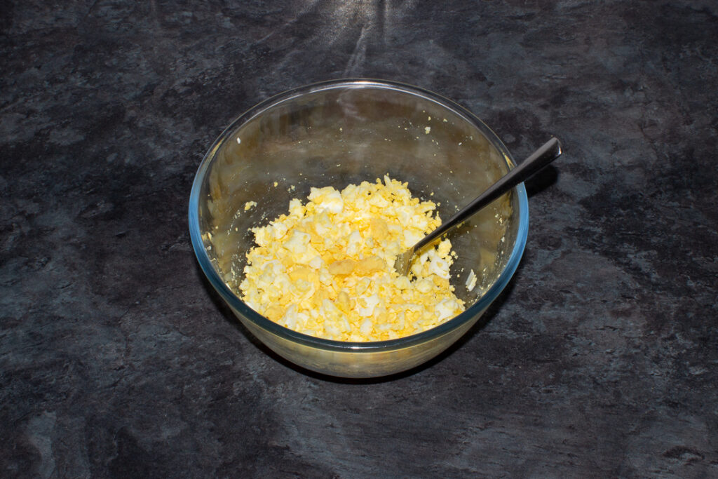 Mashed eggs in a large glass bowl