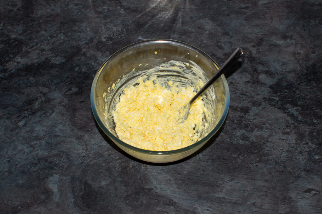 Egg mayo in a glass bowl with a fork