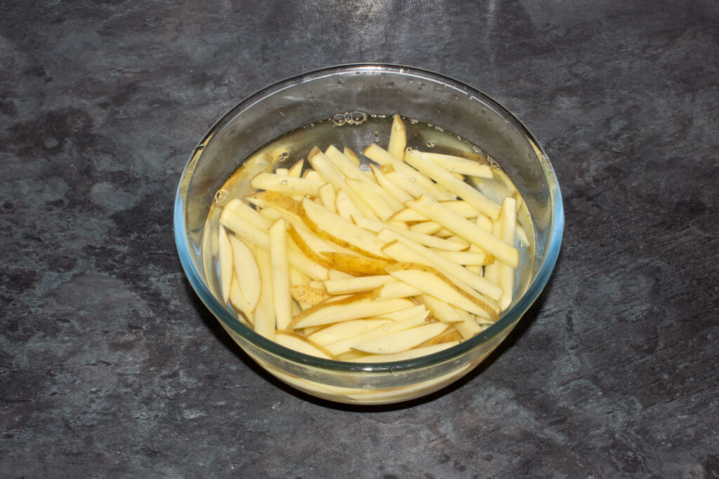Fries soaking in a bowl of cold water