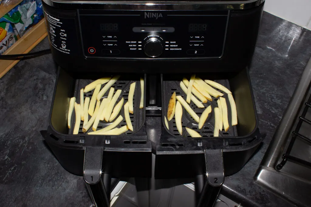 Fries placed in air fryer baskets