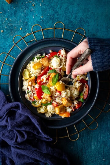 Someone forking a bowl of rice salad