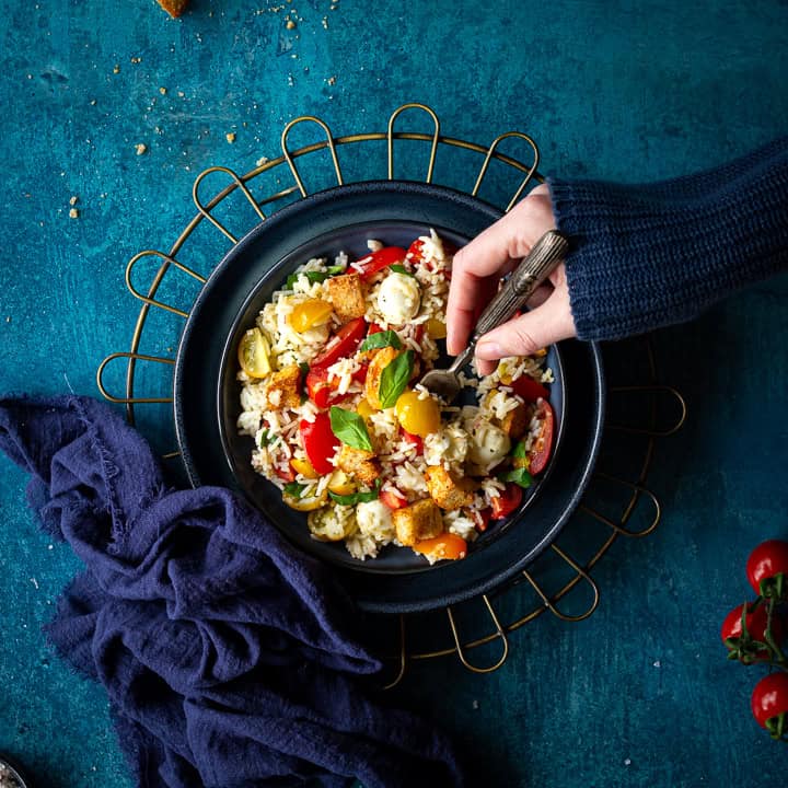 Someone forking a bowl of rice salad