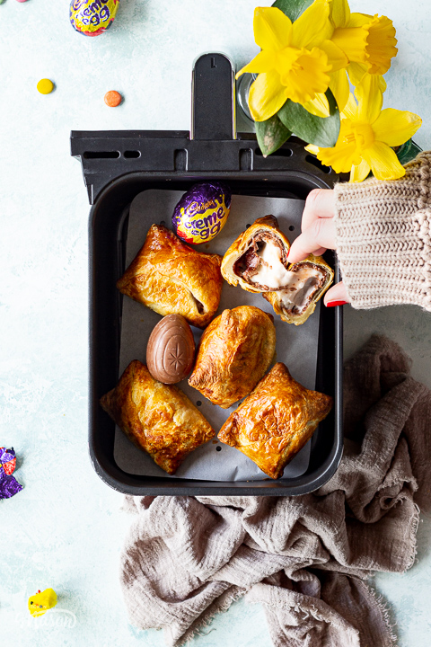 Someone taking an air fried Creme Egg croissant from an air fryer drawer