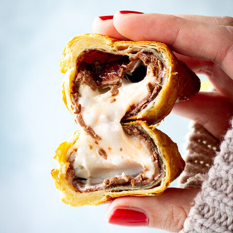 A close up of someone holding an air fried Creme Egg croissant cut in half