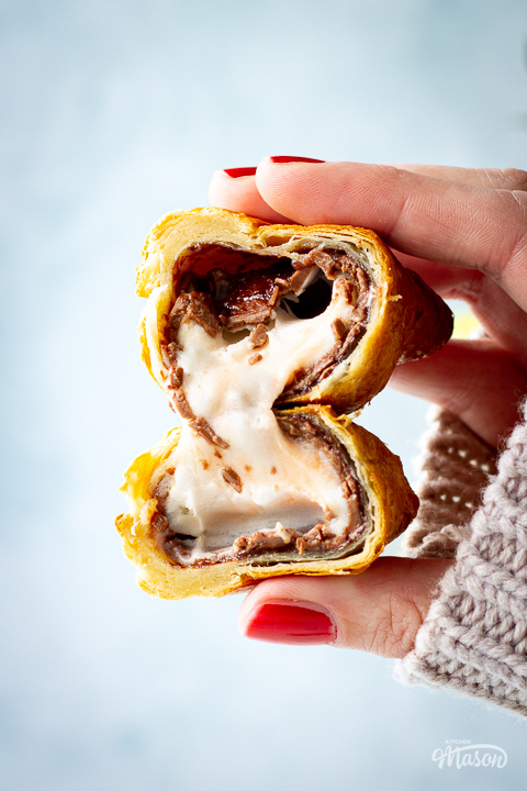 A close up of someone holding an air fried Creme Egg croissant cut in half